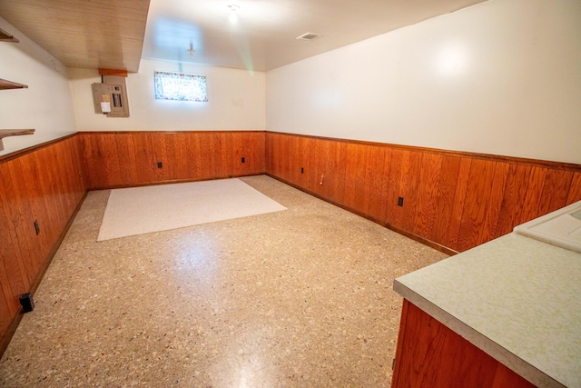 5774 N Wayne Ave, Pentwater, MI 49449 - basement featuring a wainscoted wall, wooden walls, and electric panel
