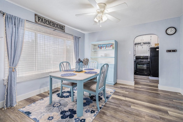 378 Goguac St W, Battle Creek, MI 49015 - dining space featuring wood finished floors, ceiling fan, and arched walkways