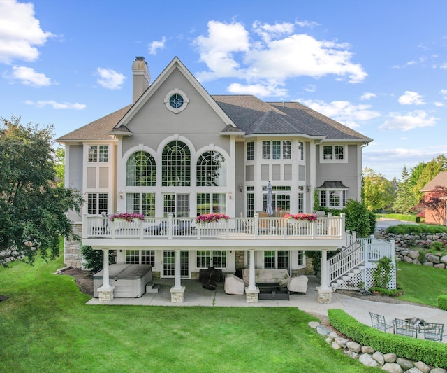 5011 Rockaway Ln, Clarkston, MI 48348 - back of house featuring a patio, a lawn, stucco siding, a hot tub, and a chimney