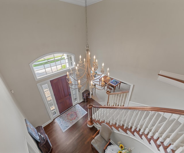 5011 Rockaway Ln, Clarkston, MI 48348 - entryway with stairway, dark wood-type flooring, a chandelier, a towering ceiling, and crown molding