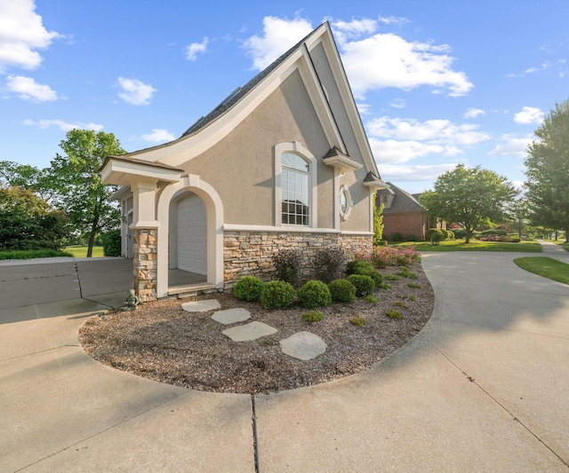 5011 Rockaway Ln, Clarkston, MI 48348 - view of property exterior with stone siding, stucco siding, and driveway
