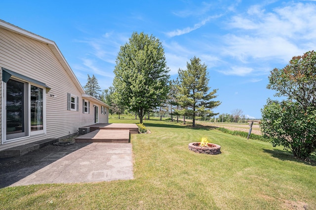 4515 S Lincoln Rd, Mount Pleasant, MI 48858 - view of grassy yard with an outdoor fire pit, a deck, and a patio area