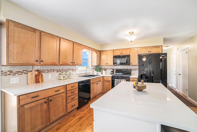 4515 S Lincoln Rd, Mount Pleasant, MI 48858 - kitchen featuring black appliances, backsplash, light wood finished floors, a kitchen island, and light countertops