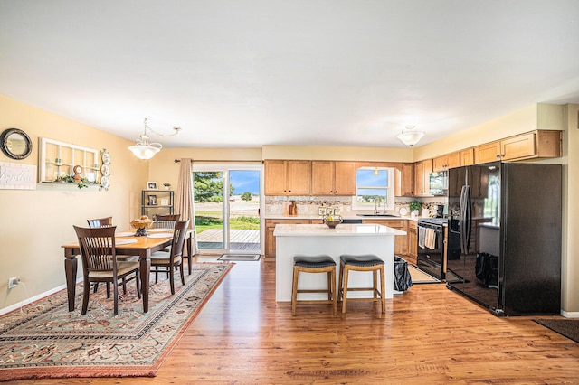 4515 S Lincoln Rd, Mount Pleasant, MI 48858 - kitchen with black appliances, healthy amount of natural light, a kitchen island, and light countertops