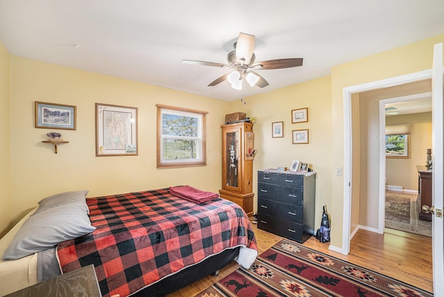 4515 S Lincoln Rd, Mount Pleasant, MI 48858 - bedroom featuring wood finished floors, multiple windows, and a ceiling fan