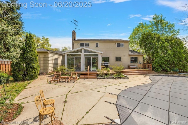 4160 Dawn Ln, West Bloomfield, MI 48323 - rear view of house featuring a sunroom, a patio, a chimney, and a wooden deck