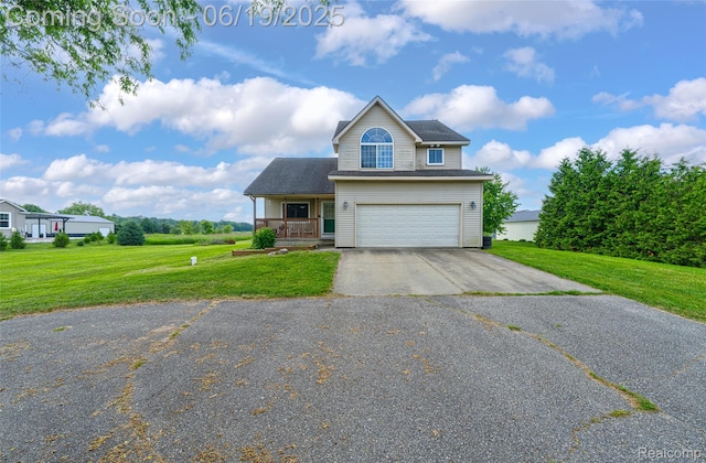 2102 Oakwood Rd, Ortonville, MI 48462 - view of front of property featuring an attached garage, asphalt driveway, a front yard, and covered porch
