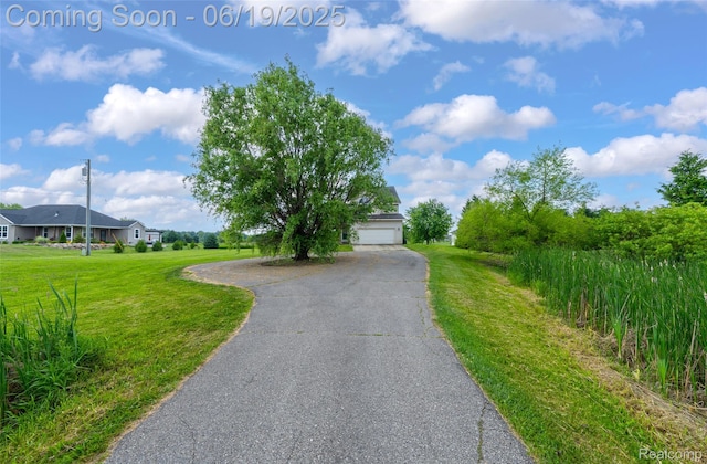 2102 Oakwood Rd, Ortonville, MI 48462 - view of front facade featuring a front lawn, driveway, and an attached garage