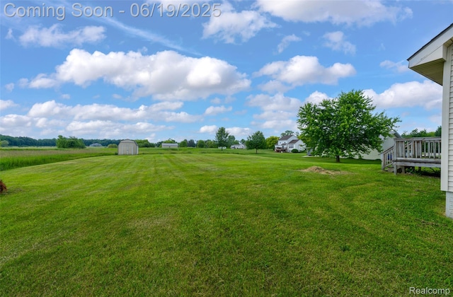 2102 Oakwood Rd, Ortonville, MI 48462 - view of grassy yard with a storage unit and a wooden deck