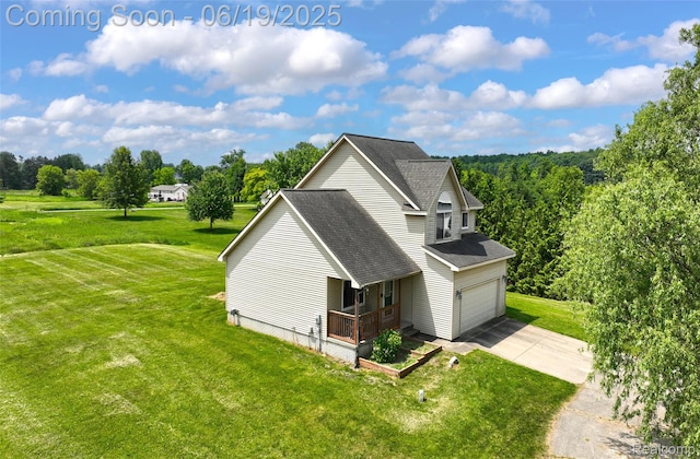 2102 Oakwood Rd, Ortonville, MI 48462 - view of home's exterior with a yard, a porch, driveway, a shingled roof, and a garage