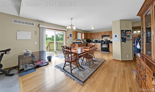 2102 Oakwood Rd, Ortonville, MI 48462 - dining area featuring a chandelier and light wood-style flooring