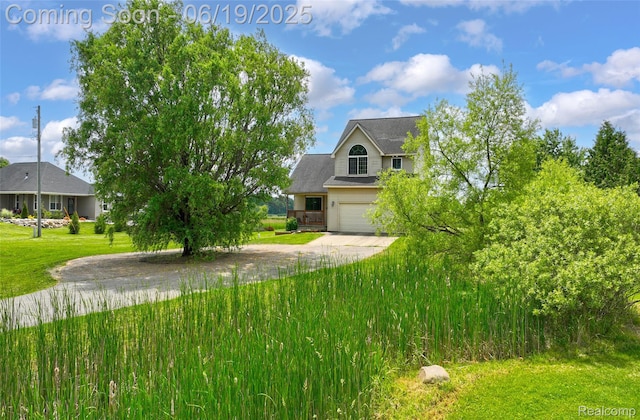 2102 Oakwood Rd, Ortonville, MI 48462 - view of front facade featuring driveway, a garage, and a front yard