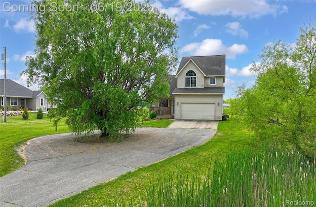 2102 Oakwood Rd, Ortonville, MI 48462 - view of front facade featuring driveway, an attached garage, and a front yard
