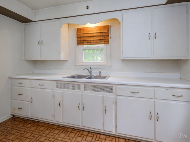 223 Ruth St, Portage, MI 49002 - kitchen featuring white cabinets, light countertops, and brick patterned floors