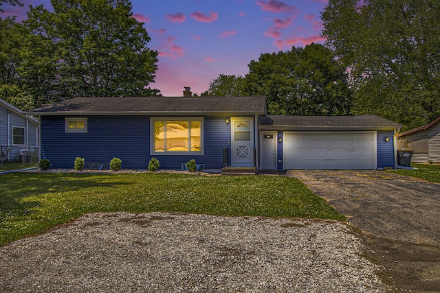 8814 S Sprinkle Rd, Portage, MI 49002 - view of front of property featuring asphalt driveway, a garage, a yard, and a chimney
