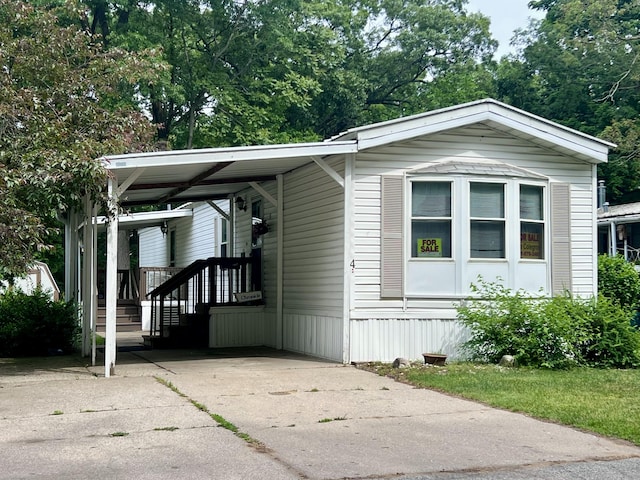 2701 Huizenga St Trlr # 4, Norton Shores, MI 49444 - manufactured / mobile home featuring driveway and a carport