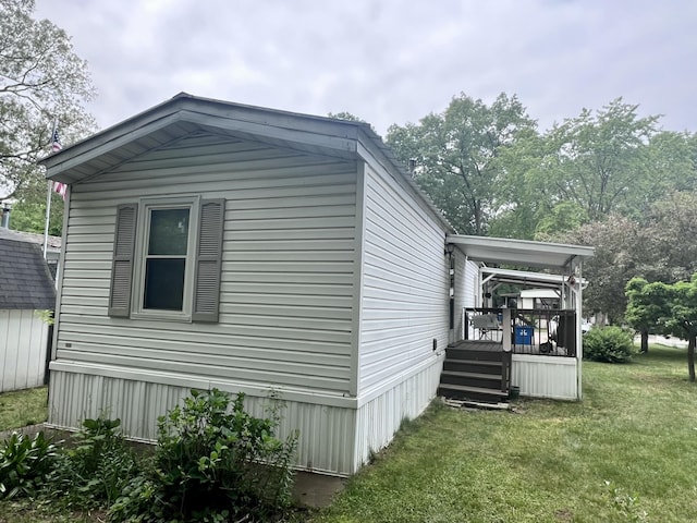 2701 Huizenga St Trlr # 4, Norton Shores, MI 49444 - view of side of property with a lawn and a deck