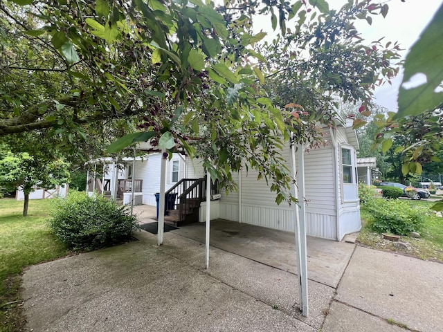 2701 Huizenga St Trlr # 4, Norton Shores, MI 49444 - view of patio featuring concrete driveway and a carport