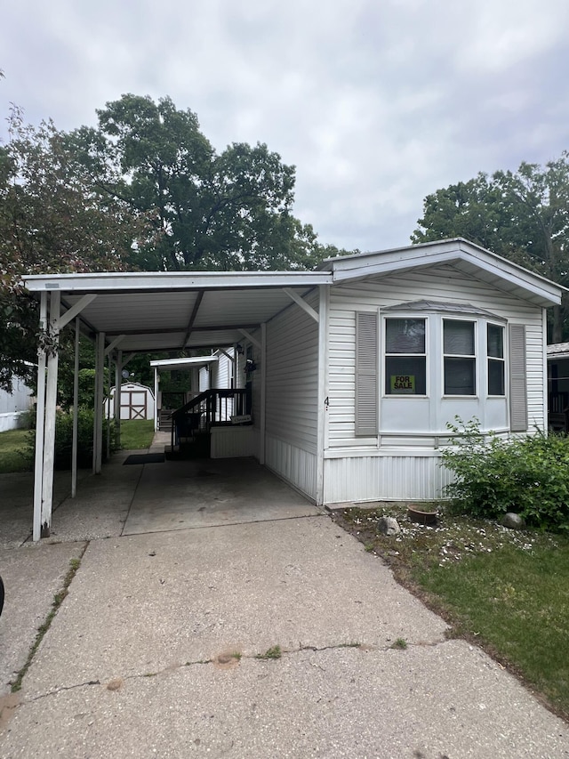 2701 Huizenga St Trlr # 4, Norton Shores, MI 49444 - manufactured / mobile home with driveway, a storage unit, and a carport