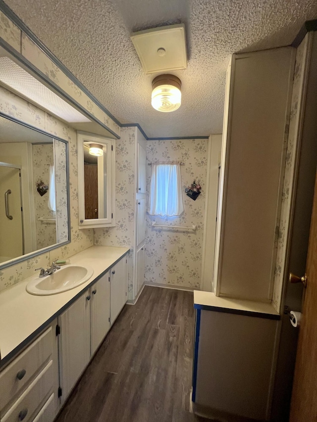 2701 Huizenga St Trlr # 4, Norton Shores, MI 49444 - full bathroom with wallpapered walls, wood finished floors, vanity, a textured ceiling, and a stall shower