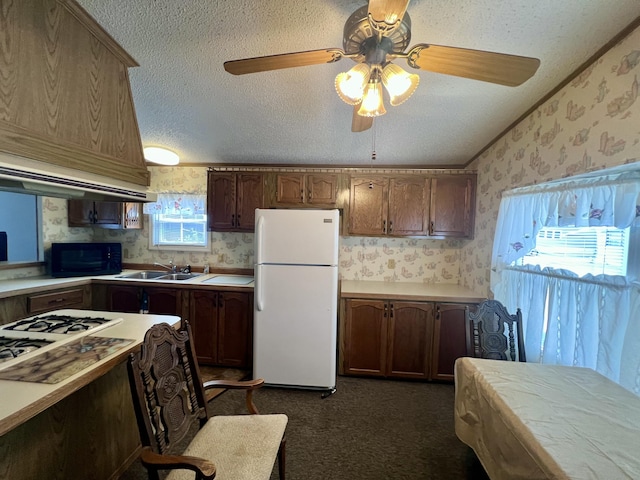 2701 Huizenga St Trlr # 4, Norton Shores, MI 49444 - kitchen with freestanding refrigerator, wallpapered walls, black microwave, a textured ceiling, and a ceiling fan