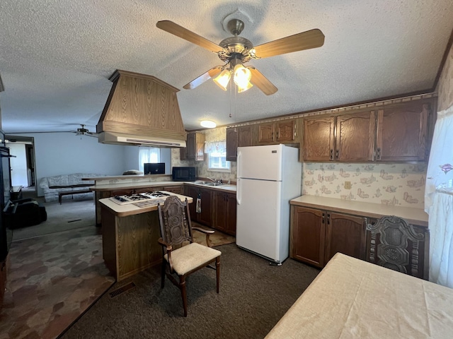 2701 Huizenga St Trlr # 4, Norton Shores, MI 49444 - kitchen featuring freestanding refrigerator, black microwave, ceiling fan, a textured ceiling, and a peninsula