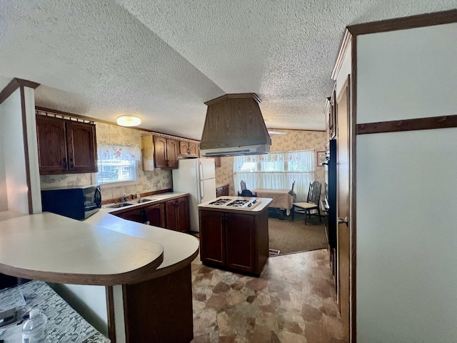 2701 Huizenga St Trlr # 4, Norton Shores, MI 49444 - kitchen with white appliances, custom exhaust hood, a peninsula, wallpapered walls, and light countertops