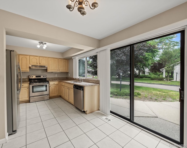 1829 Golf Ridge Dr, Bloomfield Hills, MI 48302 - kitchen with stainless steel appliances, light brown cabinetry, under cabinet range hood, light tile patterned floors, and a chandelier