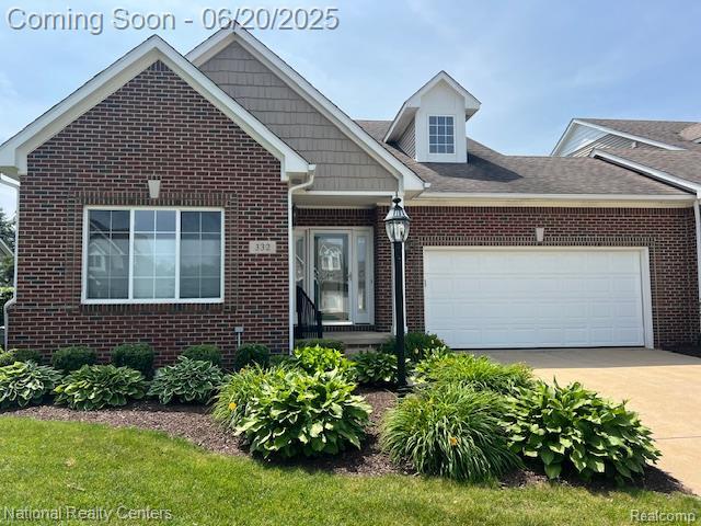 332 Asbury Ct, Highland, MI 48357 - view of front of property with brick siding, driveway, and a garage