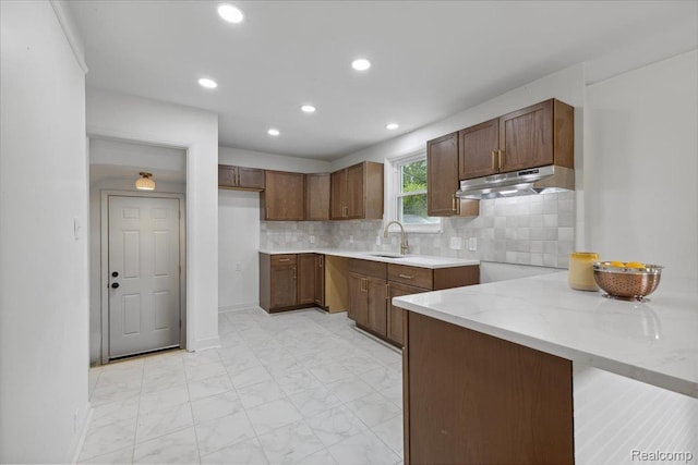 3900 Somerset Ave, Grosse Pointe Woods, MI 48224 - kitchen featuring under cabinet range hood, light marble finish flooring, recessed lighting, decorative backsplash, and light stone counters