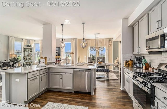 8757 Grove St, Washington, MI 48094 - kitchen featuring stainless steel appliances, gray cabinetry, a peninsula, and dark wood-style flooring