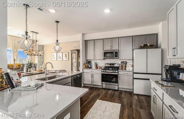 8757 Grove St, Washington, MI 48094 - kitchen featuring stainless steel appliances, gray cabinets, backsplash, decorative light fixtures, and light stone countertops