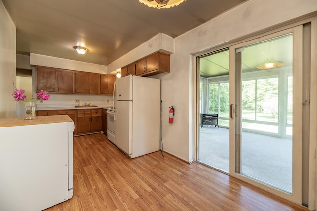 10229 N 22nd St, Plainwell, MI 49080 - kitchen featuring white appliances, light wood-type flooring, light countertops, and brown cabinets