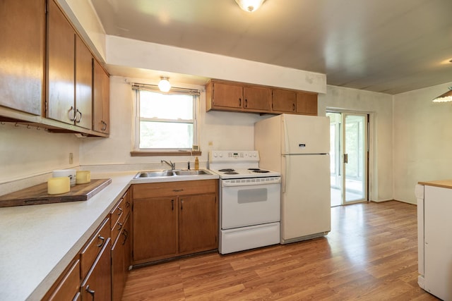 10229 N 22nd St, Plainwell, MI 49080 - kitchen featuring white appliances, healthy amount of natural light, brown cabinetry, and light wood-type flooring