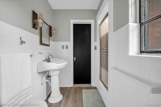 5500 Harvard Rd, Detroit, MI 48224 - full bath with tile walls, wood finished floors, a shower with shower door, and a wainscoted wall