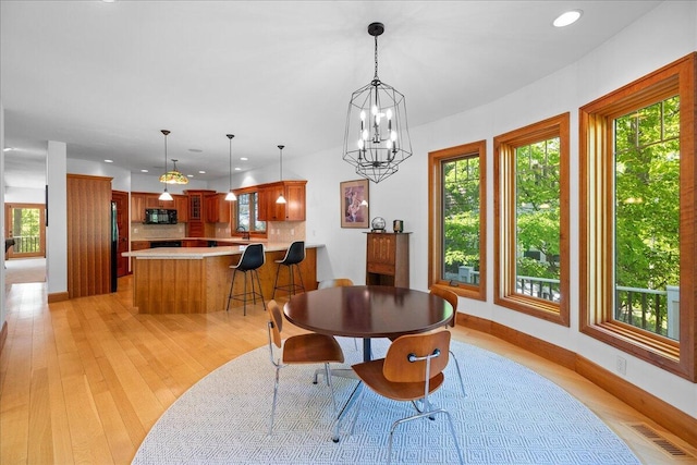 4679-4681 Forest Ridge Dr, Holland, MI 49423 - dining room with healthy amount of natural light, recessed lighting, light wood-style flooring, and a chandelier