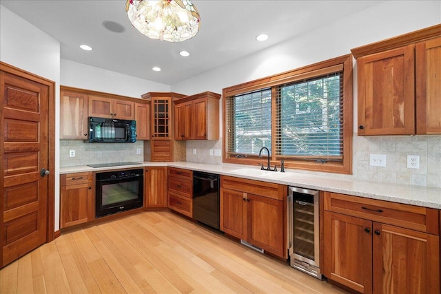 4679-4681 Forest Ridge Dr, Holland, MI 49423 - kitchen featuring black appliances, beverage cooler, brown cabinetry, light wood finished floors, and tasteful backsplash