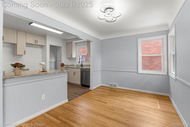 8276 Riverview St, Dearborn Heights, MI 48127 - kitchen with stainless steel dishwasher, light wood-style flooring, and light stone countertops