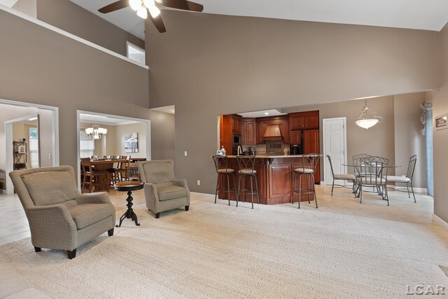 3054 Windmill Dr, Adrian, MI 49221 - living room with ceiling fan, a towering ceiling, a chandelier, light carpet, and healthy amount of natural light