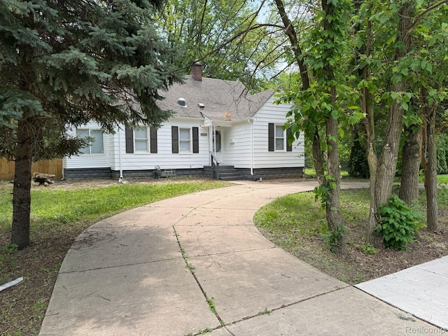 28905 Hennepin St, Dearborn Heights, MI 48135 - view of front of property with roof with shingles, driveway, and a chimney