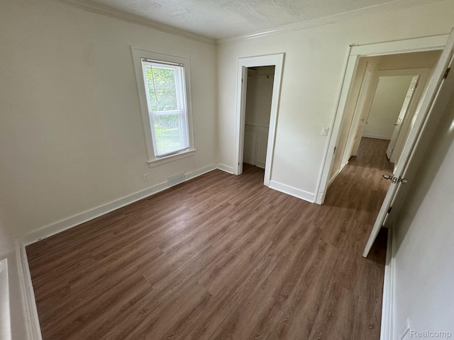 28905 Hennepin St, Dearborn Heights, MI 48135 - unfurnished bedroom featuring dark wood finished floors, ornamental molding, a textured ceiling, and a closet