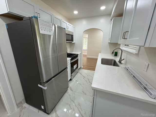 28905 Hennepin St, Dearborn Heights, MI 48135 - kitchen featuring appliances with stainless steel finishes, light marble finish floors, arched walkways, light stone countertops, and recessed lighting