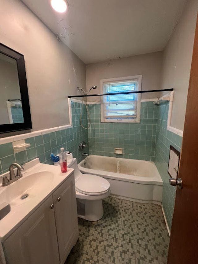 3501 Fleming Rd, Flint, MI 48504 - full bath with vanity, washtub / shower combination, tile walls, tile patterned floors, and a wainscoted wall