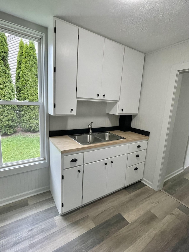 301 W State St, Corunna, MI 48817 - kitchen with light wood-style floors, white cabinetry, and light countertops