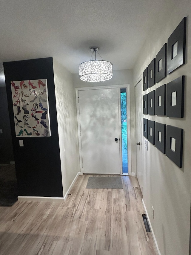 219 Walnut Woods Ct, Plainwell, MI 49080 - foyer entrance featuring light wood-style flooring and a chandelier