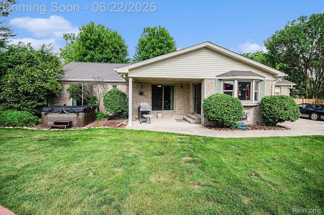 9300 Clippert St, Taylor, MI 48180 - back of house with a hot tub, brick siding, a patio, and a lawn