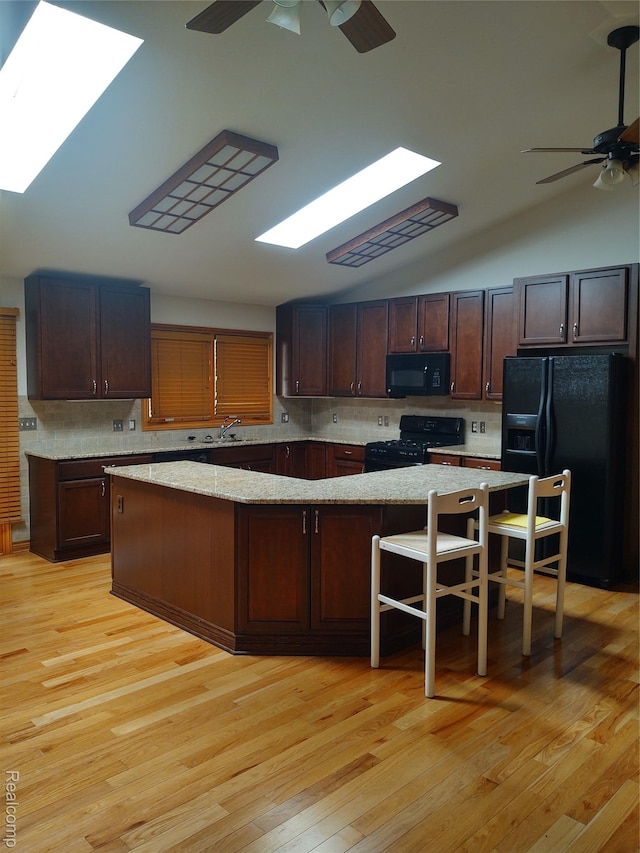 8996 Main St, Whitmore Lake, MI 48189 - kitchen with black appliances, ceiling fan, a skylight, light wood finished floors, and lofted ceiling