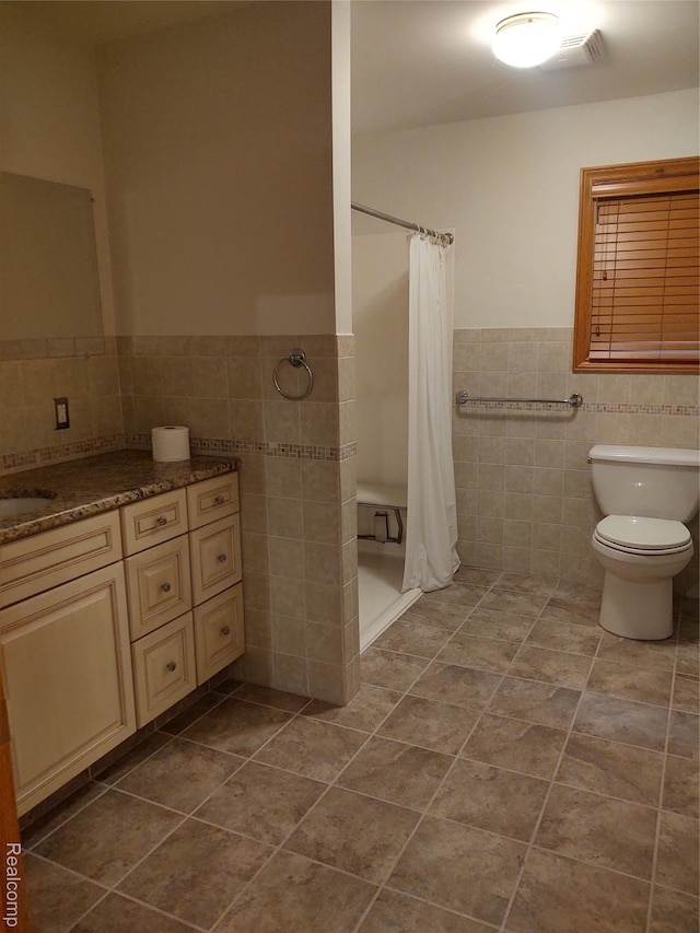 8996 Main St, Whitmore Lake, MI 48189 - full bath featuring tile walls, tile patterned floors, a shower stall, a wainscoted wall, and vanity