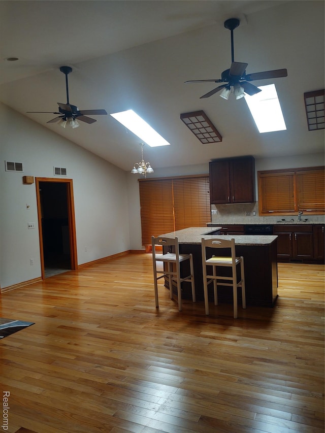 8996 Main St, Whitmore Lake, MI 48189 - kitchen with a ceiling fan, a skylight, high vaulted ceiling, a chandelier, and light wood-style flooring