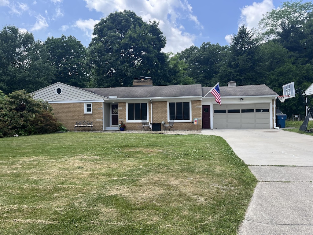 4340 Sunset Dr, Kalamazoo, MI 49008 - single story home with a chimney, a garage, brick siding, driveway, and a front lawn